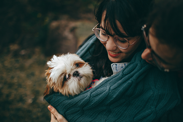 Woman and her dog wrapped in a blanket.