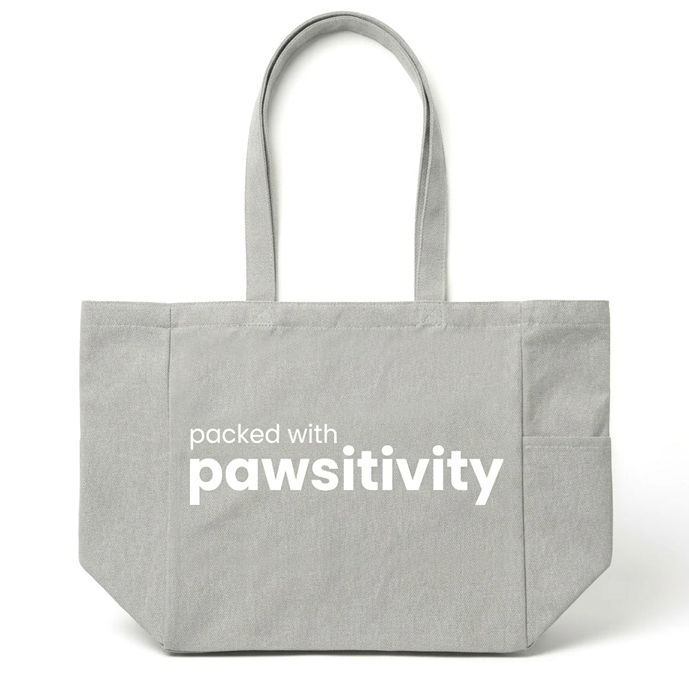 Large beige tote bag with "Pawsitivity" printed on the front, featuring sturdy handles and spacious interior, by KindTail.
