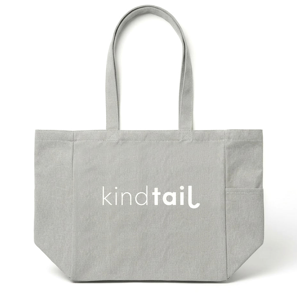 Large beige tote bag with "Pawsitivity" text and paw print design, made by KindTail, showing the front view of the oversized tote.