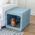 KindTail PAWD® | Modern Collapsible Plastic Dog & Pet Crate in medium blue with a brown dog sitting in side