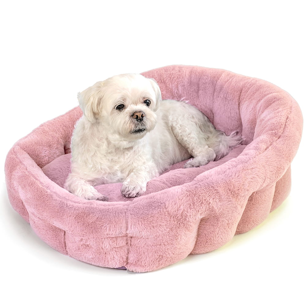 Pink calming dog bed by KindTail with plush, padded design for comfort and rest.