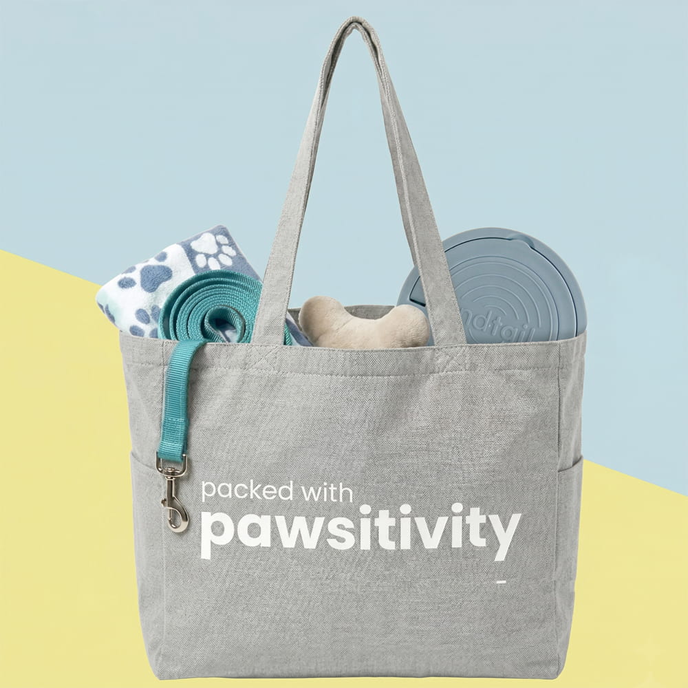 Large beige tote bag from KindTail Pawsitivity collection featuring paw print designs and sturdy handles.